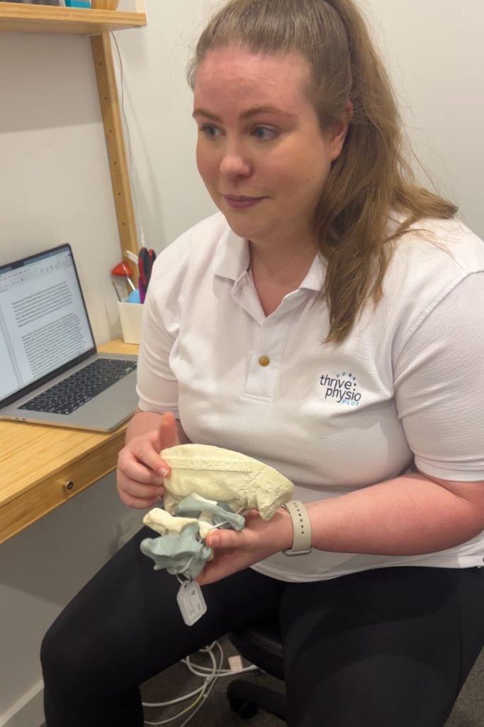 Headache Physiotherapist Kate pointing to a neck model during a headache physio consultation